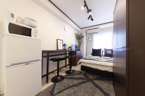 a small bedroom with a bed and a desk at Chez Moi royale in Tokyo