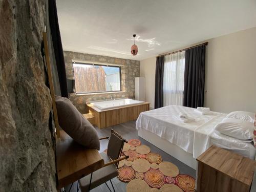 フェティエにあるÜzümlü Taş Villaのベッドとバスタブ付きのホテルルームです。