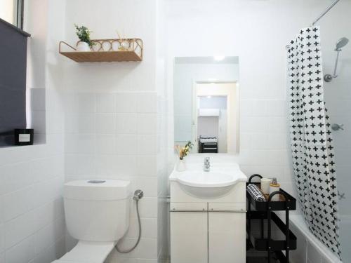 a white bathroom with a toilet and a sink at Central Perth Loft River Views in Perth