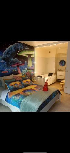 - une chambre avec un grand lit orné d'une fresque murale sur les dinosaures dans l'établissement Petite perle, à Boulogne-Billancourt