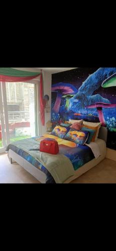 - une chambre avec un grand lit orné d'un mur de dinosaures dans l'établissement Petite perle, à Boulogne-Billancourt