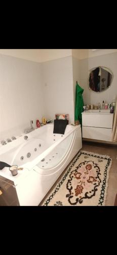 - une baignoire blanche dans une chambre avec tapis dans l'établissement Petite perle, à Boulogne-Billancourt