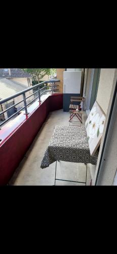- un balcon avec un banc et une chaise dans un bâtiment dans l'établissement Petite perle, à Boulogne-Billancourt
