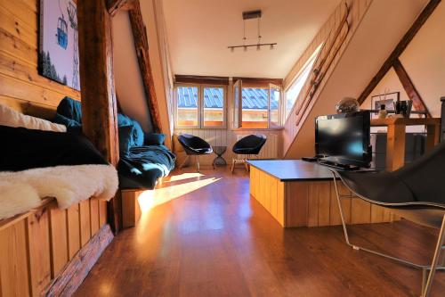 sala de estar con sofá, mesa y sillas en Superbe appartement esprit chalet, en Barcelonnette