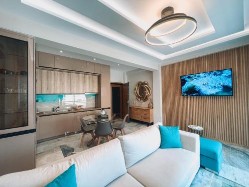 a living room with a white couch and a kitchen at AGORA luxury APARTMENT 8 in Loutraki