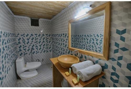 a bathroom with a sink and a toilet and a mirror at The Jaisalmer Heritage Safari Camp in Sām
