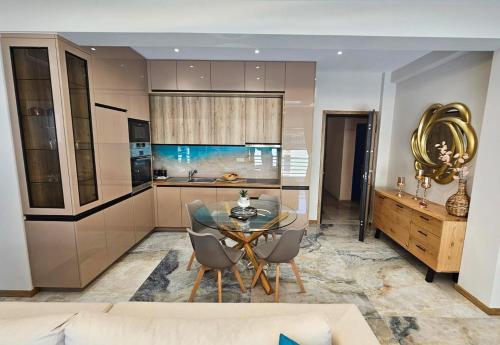 a kitchen with a glass table and chairs in a room at AGORA luxury APARTMENT 8 in Loutraki