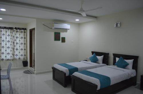 two beds in a room with white walls at HOTEL VIRAT INN in Hyderabad