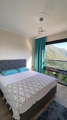 a bedroom with a bed and a large window at Villa Camgüzeli Kivili Konak’ta! in Fethiye
