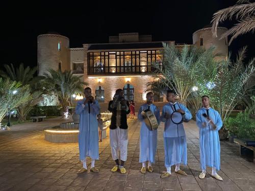 un groupe de personnes debout devant un bâtiment dans l'établissement Palais Du Desert Hotel & Spa, à Erfoud