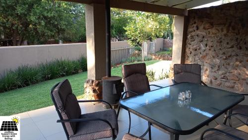 a table and chairs sitting on a patio at SnL Guesthouse at Visarend in Malelane