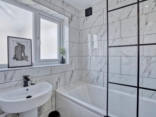 a white bathroom with a tub and a sink at Pass the Keys Modern 3 Bed House Near Etihad Stadium in Manchester