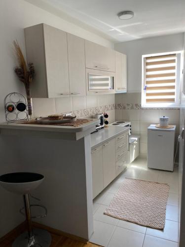 a kitchen with white cabinets and a counter top at MKA suite in Kragujevac