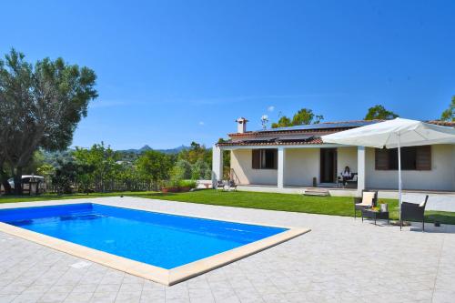 a swimming pool in front of a house at Gli Olivastri Guest House in Arzachena