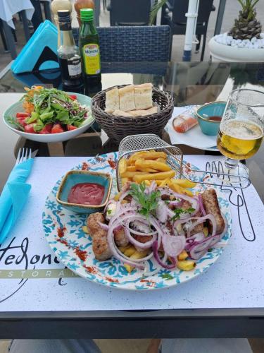 a plate of food on a table with bread and vegetables at Hotel Vila Hedonija in Herceg-Novi
