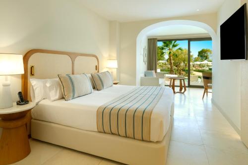 a bedroom with a large bed and a living room at TRS Ibiza Hotel -All Inclusive Adults Only in San Antonio