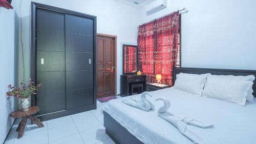 1 dormitorio con 1 cama grande y cortina roja en Villa Malang Puncak Buring en Malang