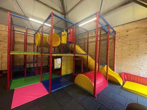 a play room with a slide and swings at Vakantiepark Eigen Wijze in Bant