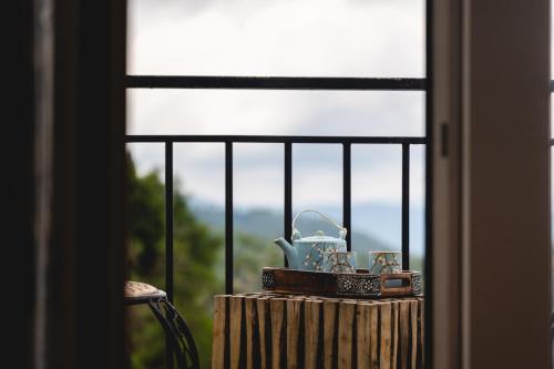 a box with a tea kettle on a window sill at The Soul Stroll Cottages Retreat in Mukteswar