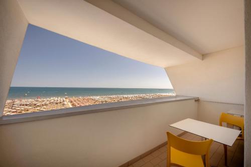 um quarto com uma janela com vista para a praia em Hotel Parigi em Caorle