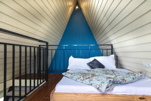 a bed in a room with a blue wall at The Soul Stroll Cottages Retreat in Mukteswar