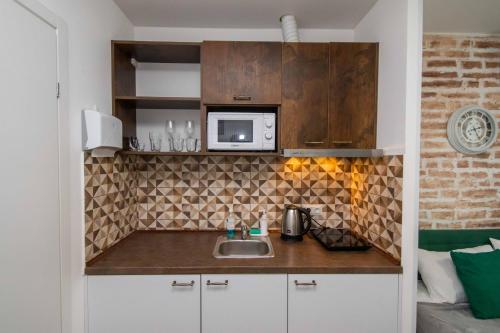 a kitchen with a sink and a microwave at Апартаменти MYFREEDOM поруч із метро Тараса Шевченка in Kyiv