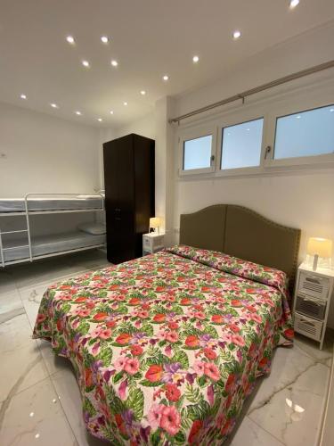 a bedroom with a bed with a floral bedspread at Pinetina Beach in Bibione
