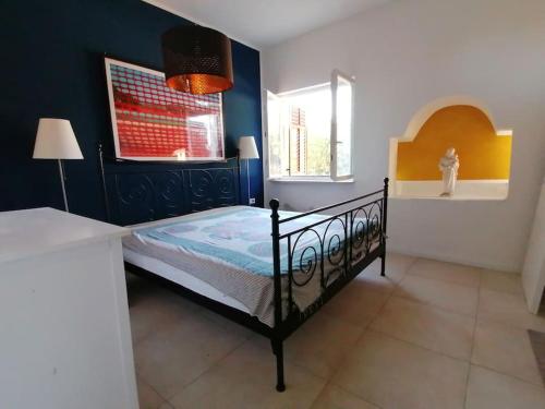 a bedroom with a black bed and a window at Villa Rapunzel in Brovinje