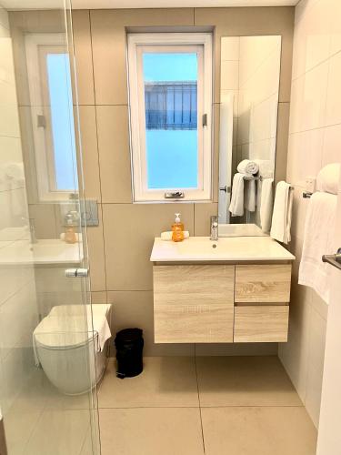 a bathroom with a sink and a glass shower at Victorian Terrace in the heart of it all! in Melbourne