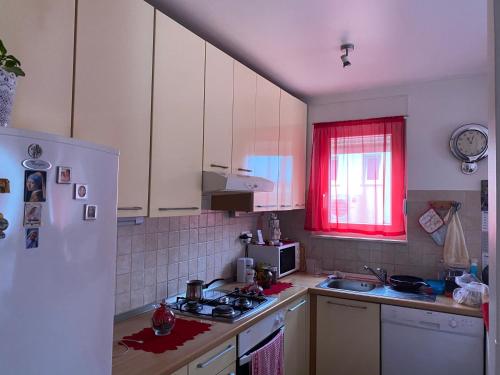 a kitchen with a white refrigerator and a red window at Cozy Room + shared kitchen + shared bathroom + free parking in Hvar