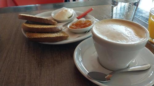a cup of coffee and a plate of bread and toast at Casa entre Montañas in San Juan