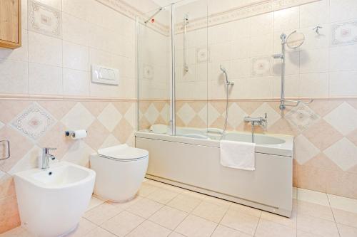 a bathroom with a toilet and a tub and a sink at Villa Porpora Luxury Design in Modena