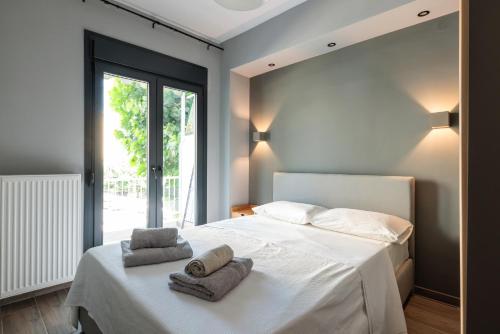 a bedroom with a white bed with towels on it at Hippocrates bound by BiNoBi! in Thessaloniki