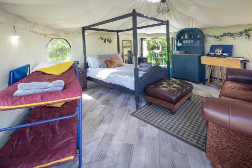 een slaapkamer in een tent met een bed en een bureau bij West Point Woods in Barrow in Furness