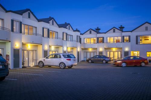 a group of cars parked in a parking lot in front of a building at Cornwall Motor Lodge in Palmerston North