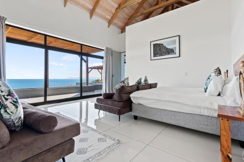 - une chambre avec un lit et une vue sur l'océan dans l'établissement Romansbaai Moksha on the Sea, à Gansbaai