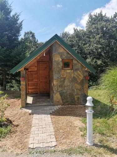 eine kleine Hütte mit einer Holztür im Hof in der Unterkunft Bungalov Živković in Mojkovac
