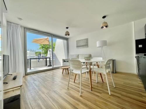 une salle à manger avec une table et des chaises et une grande fenêtre dans l'établissement PGH N14 - 200m de la Plage avec Parking Privé, à La Grande Motte