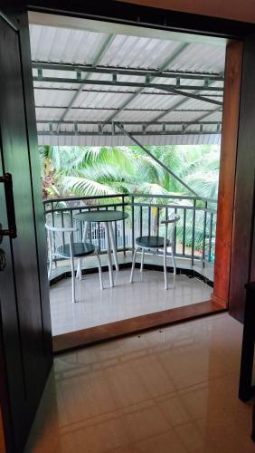 a balcony with two chairs and a table on it at La maison de Soriya - Homestay in Kampot