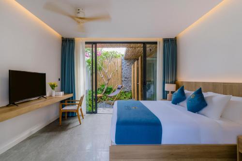 a bedroom with a large bed and a television at Fleur de Lys Resort & Spa Long Hai in Long Hai