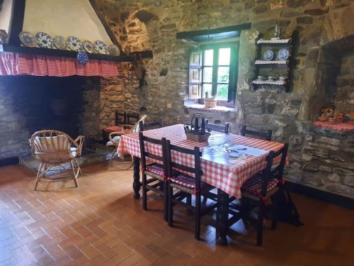 a dining room with a table and chairs and a stone wall at Casa Rural Goikitxe Etxea in Goizueta