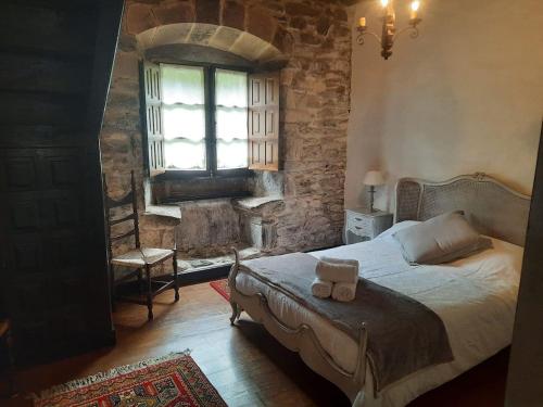 - une chambre avec un lit, une fenêtre et une chaise dans l'établissement Casa Rural Goikitxe Etxea, à Goizueta