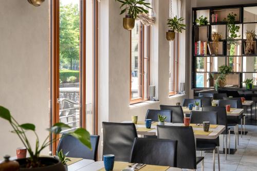 a restaurant with tables and chairs and windows at INNSiDE by Meliá Leipzig in Leipzig