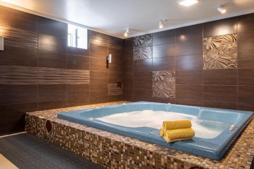 a bathroom with a large tub with a yellow towel in it at Bellevue Park Hotel Riga with FREE Parking in Rīga