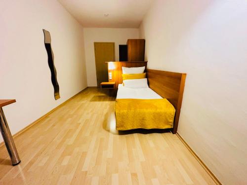 a small bedroom with a bed with a yellow blanket at Pilstinger Hof in Pilsting