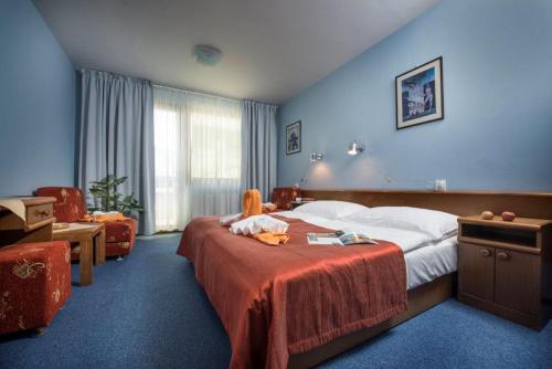 a hotel room with a bed with a stuffed animal on it at Hotel SOREA ĽUBOVŇA in Stará Ľubovňa