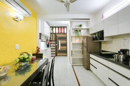 a kitchen with white cabinets and a yellow wall at Moydom Nice & Cosy Private 1 BHK Apartment OPP NFC market in New Delhi