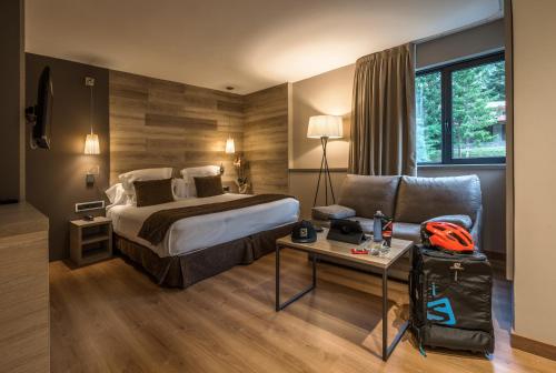 Habitación de hotel con cama y silla en Tuc Blanc, en Baqueira Beret