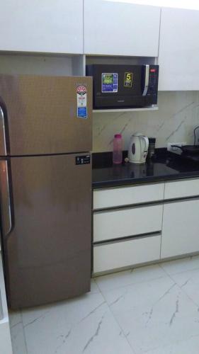 a kitchen with a stainless steel refrigerator and a microwave at Moydom Nice & Cosy Private 1 BHK Apartment OPP NFC market in New Delhi