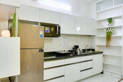 a kitchen with white cabinets and a stainless steel refrigerator at Moydom Nice & Cosy Private 1 BHK Apartment OPP NFC market in New Delhi